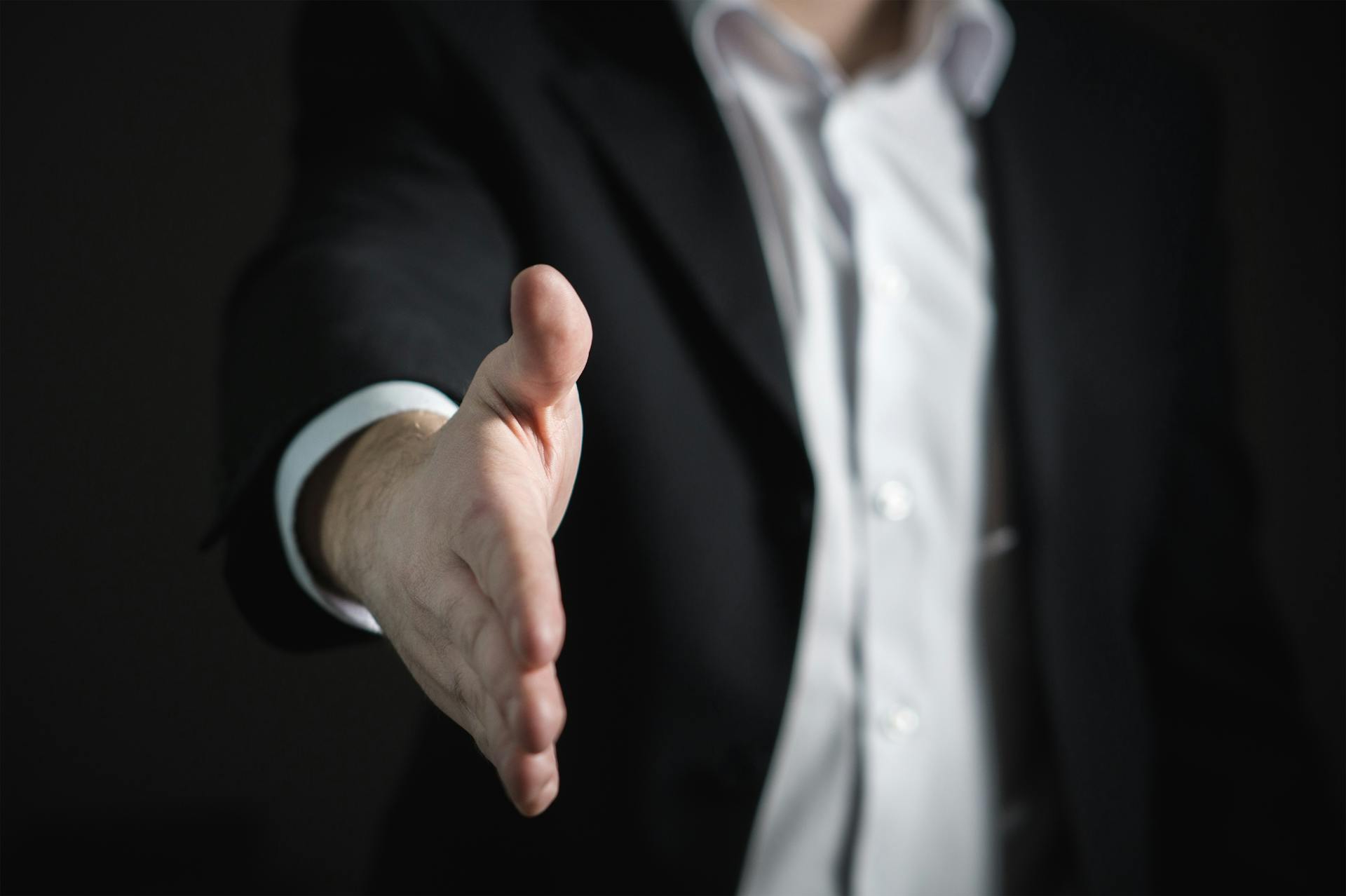 A businessman extends his hand. Administrator or executive.