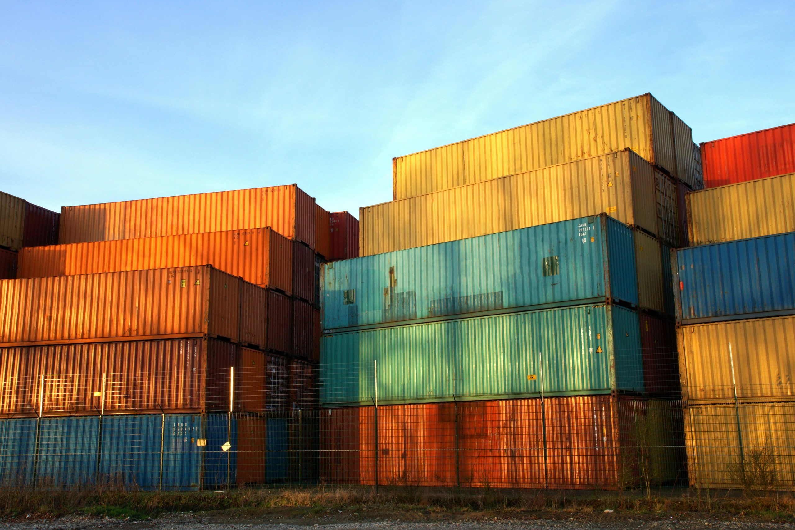 Colorful shipping containers stacked at a port.