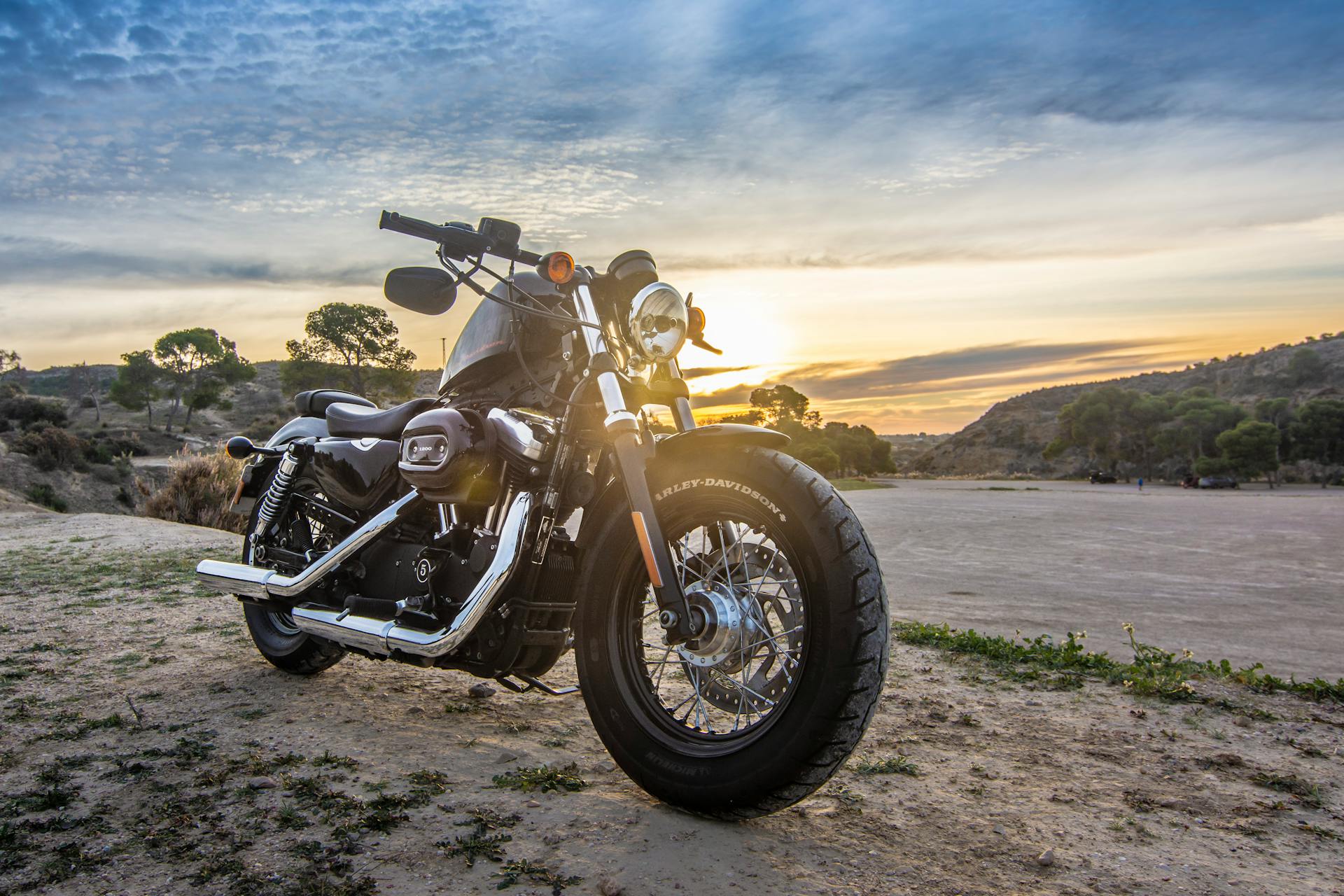 Black Harley-Davidson motorcycle with a sunset.