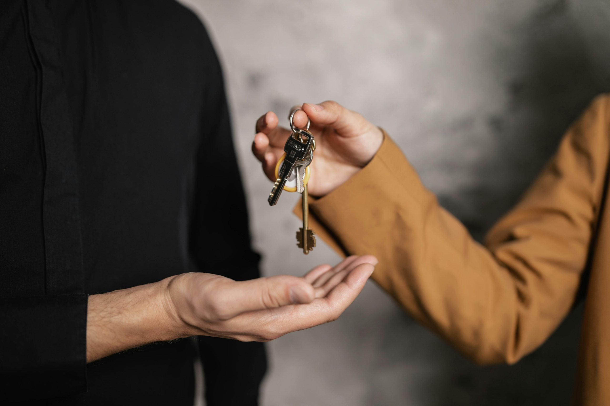 A landlord hands over a key to the tenant