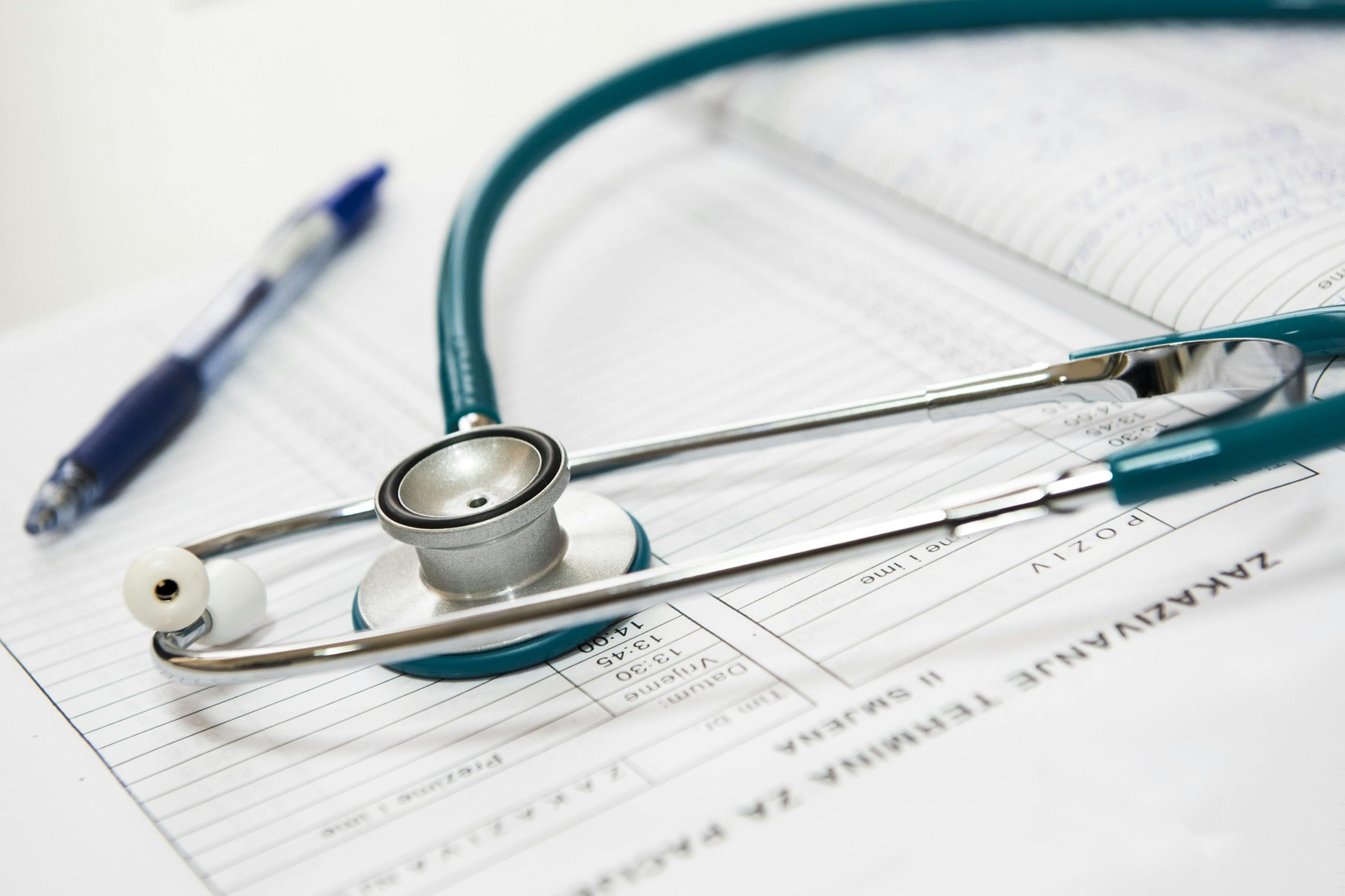 Stétoscope sur une fiche médicale avec un crayon bleu.