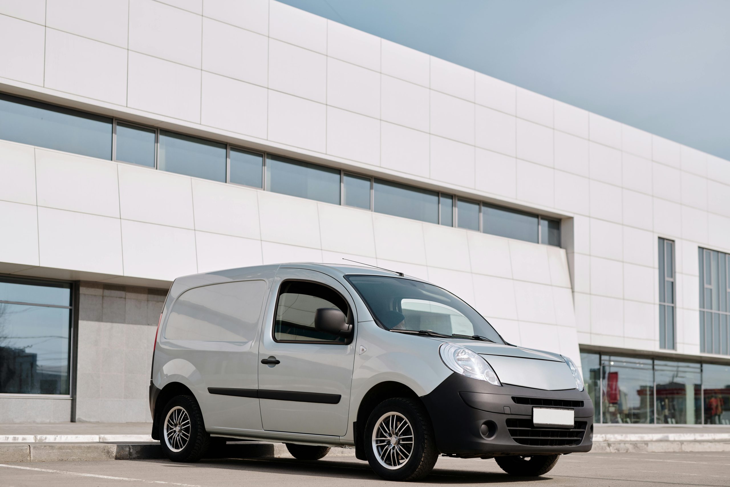 Gray commercial van in front of a building